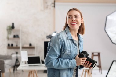 Stüdyoda profesyonel fotoğraf makinesi olan kadın fotoğrafçı.