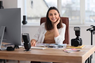 Stüdyodaki masada çalışan kadın fotoğrafçı.