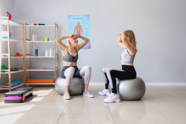 Fizyoterapisti olan genç bir kadın rehabilitasyon merkezinde yüz geliştirme egzersizi yapıyor.