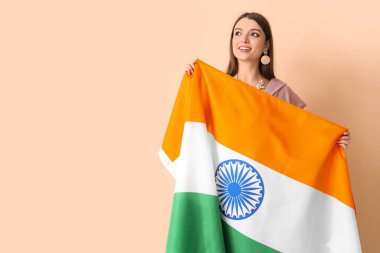 Bej arka planda Kızılderili bayrağı olan genç bir kadın.