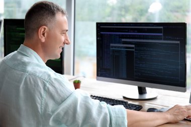 Açık ofiste çalışan olgun bir erkek programcı.