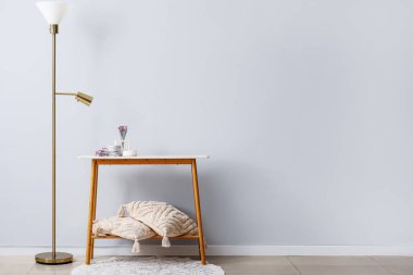 Lambalı, yastıklı ve çiçekli aydınlatma odasının içinde, masada mumlar.