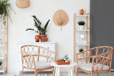 Koltukları, masası ve çiçekleri olan oturma odasının içinde.