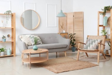 Kanepesi, koltuğu ve çiçekleri olan bir oturma odası.