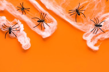 Turuncu arka planda Cadılar Bayramı partisi için örümceklerle örümcek ağı
