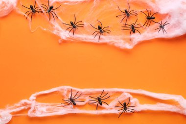 Turuncu arka planda Cadılar Bayramı partisi için örümceklerle örümcek ağı