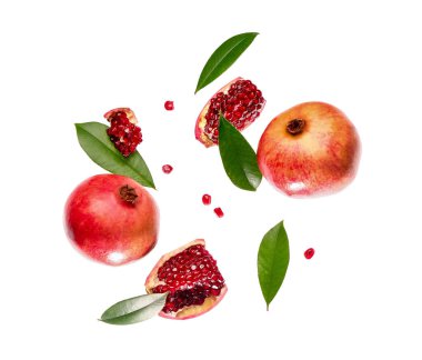 Tohumları ve yaprakları beyaz arkaplanda uçuşan taze narlar.