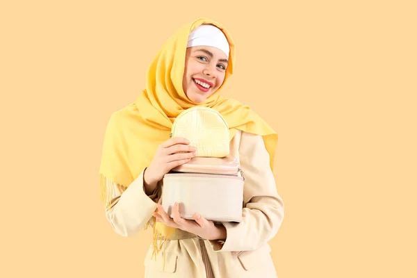 Schöne Muslimin Mit Kosmetiktaschen Auf Beigem Hintergrund — Stockfoto