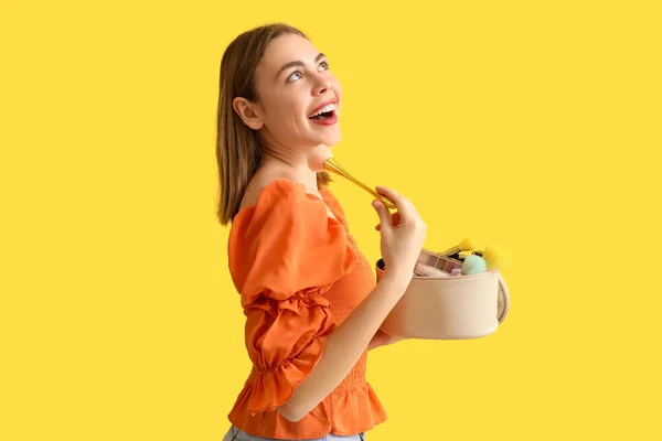 Junge Frau Mit Kosmetiktasche Und Make Pinsel Auf Gelbem Hintergrund — Stockfoto