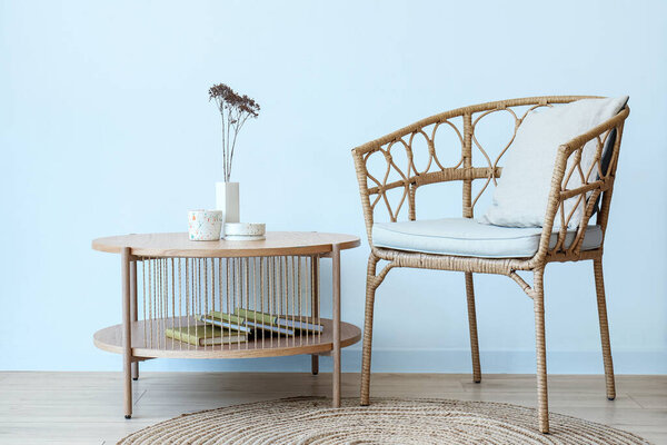 Interior of light room with flowers, candles on table and chair