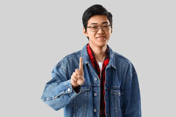 Mladý Asijský Muž Ukazující Jeden Prst Světlém Pozadí — Stock fotografie