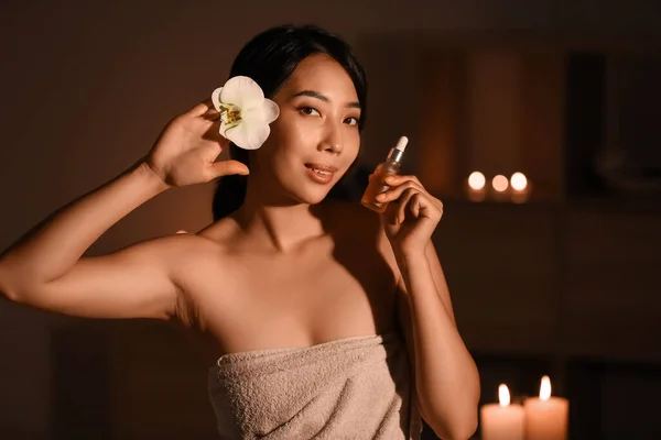 Pretty young Asian woman with essential oil in spa salon