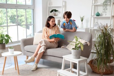 Anne, küçük oğluna ev ödevinde yardım ediyor.