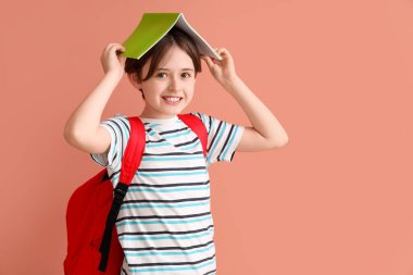 Sırt çantası ve renkli not defteri olan küçük çocuk.