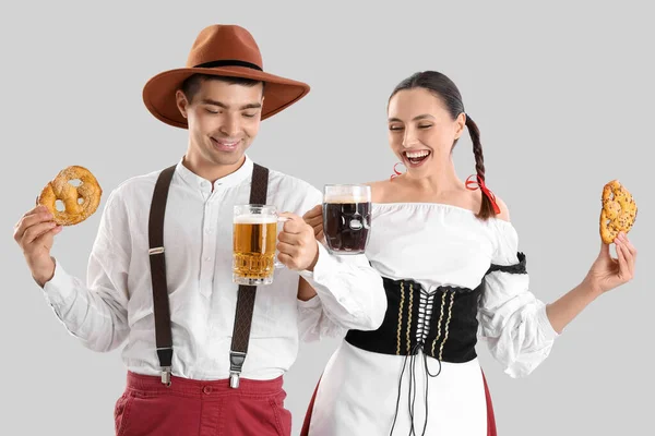 Mladý Pár Tradičním Německém Oblečení Pivem Preclíky Světlém Pozadí — Stock fotografie