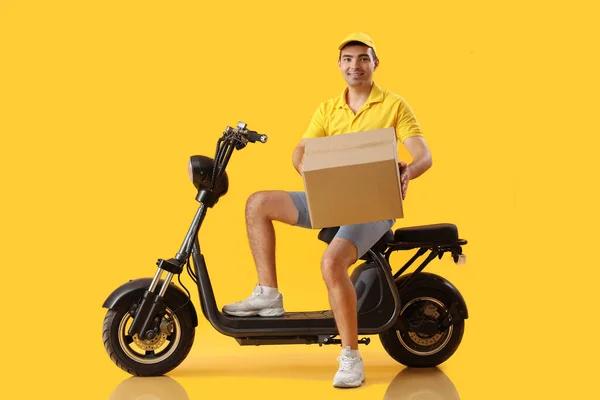 Männlicher Kurier Mit Paket Und Fahrrad Auf Gelbem Hintergrund — Stockfoto