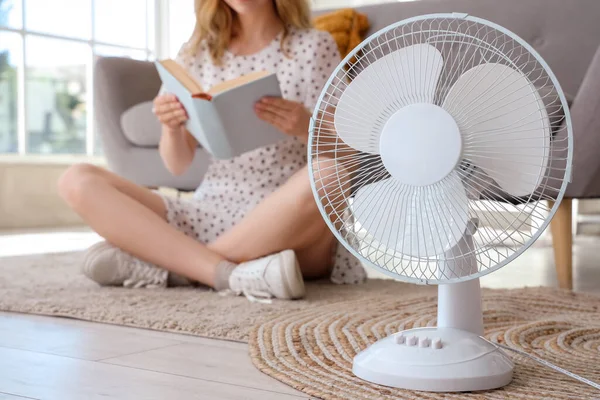 Young Woman Electric Fan Sitting Floor Reading Book Living Room — Stock Photo, Image