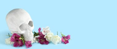 Açık mavi zemin üzerinde güzel alstromerya çiçeklerine sahip insan kafatası ve metin için boşluk