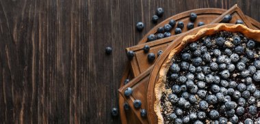 Ahşap zemin üzerinde lezzetli yaban mersini turtası ve metin için yeri olan tahtalar