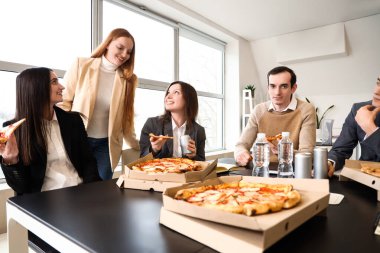 Ofisinde lezzetli pizzaları olan bir grup iş adamı.