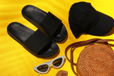Sarı arka planda şık kadın terlikleri ve aksesuarları