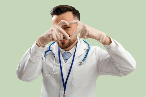 Man Läkare Gör Hjärta Med Händerna Grön Bakgrund — Stockfoto