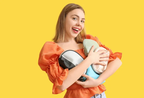 Junge Frau Mit Kosmetiktaschen Auf Gelbem Hintergrund — Stockfoto