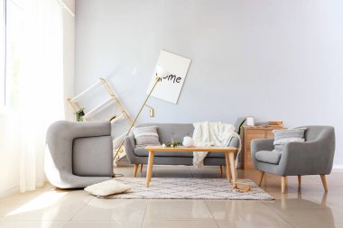 Koltuklu kanepe ve dağınık oturma odasında masa.