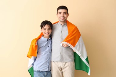 Babası ve bej arka planda Kızılderili bayrağı olan küçük bir çocuk.