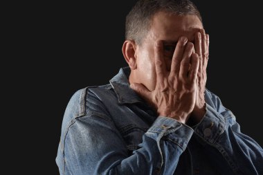 Olgun adam siyah arka planda panik atak geçiriyor, yakın plan.