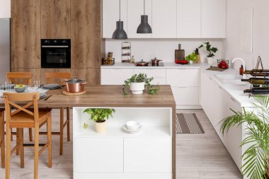 Ada masası ve beyaz tezgahlı modern mutfak.