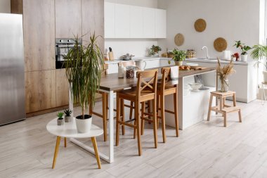 Beyaz tezgahlı, adalı ve entegre fırınlı aydınlık mutfağın içi