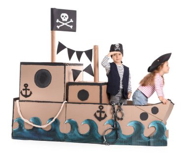 Beyaz arka planda karton gemide oynayan sevimli küçük korsanlar.