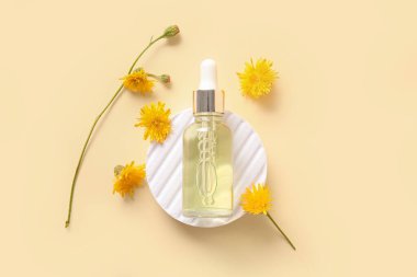 Kaliteli yağ şişesiyle sıva podyumu ve renkli arka planda güzel karahindiba çiçekleri.