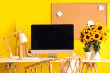 Ofisinde bilgisayar ve ayçiçekli modern işyeri