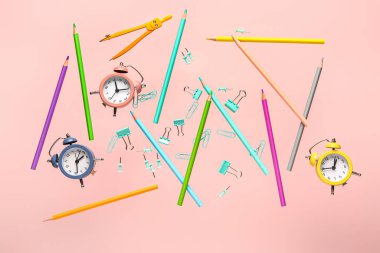 Pembe arka planda çalar saatli uçan kırtasiye