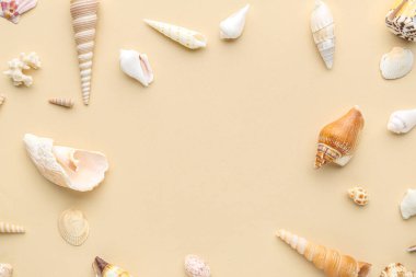 Bej arkaplanda farklı deniz kabuklarından yapılmış çerçeve