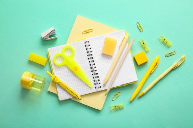 Turkuaz arka plan üzerine farklı okul kırtasiyesi ve not defterleri