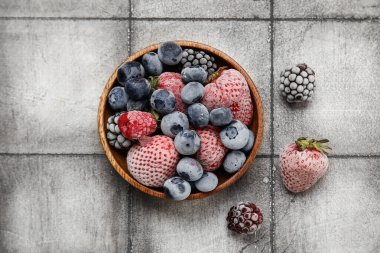 Arkaplanda bir kase donmuş çilek.