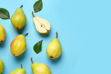 Mavi zemin üzerinde taze armutlar ve yapraklar