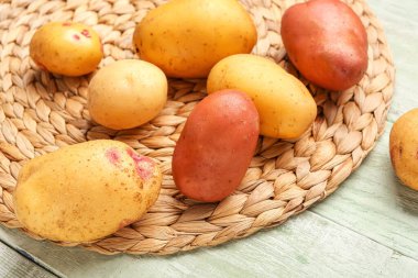 Yeşil ahşap arka planda taze çiğ patates.