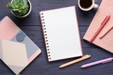 Kalemli defterler ve mavi ahşap arka planda bir fincan lezzetli kahve.