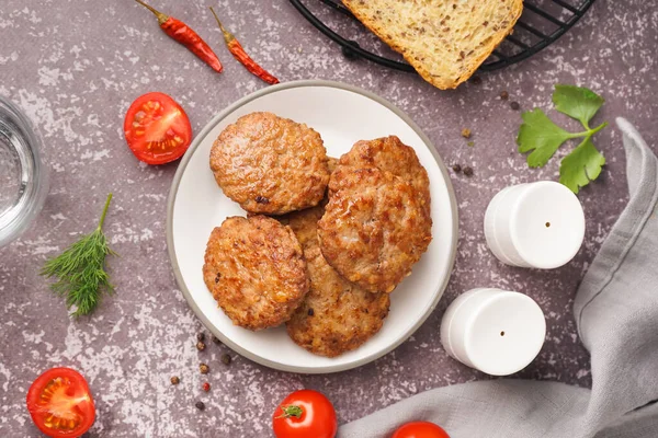 Mutfaktaki grunge masasında pirzola, domates ve biber tabağı.