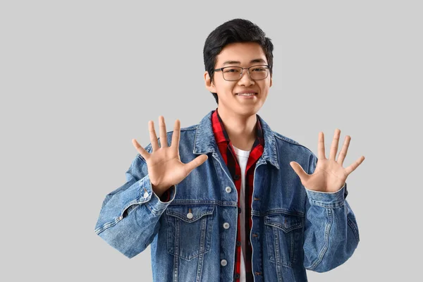 Молодой Азиат Показывает Десять Пальцев Светлом Фоне — стоковое фото