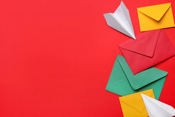 赤い背景に異なる封筒と紙飛行機のセット — ストック写真