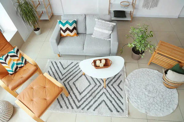 Aydınlık oturma odasının içinde bitkiler, kanepe ve koltuk, üst manzara.