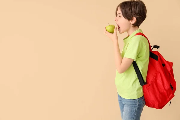 Sırt Çantalı Küçük Çocuk Bej Arka Planda Taze Elma Yiyor — Stok fotoğraf
