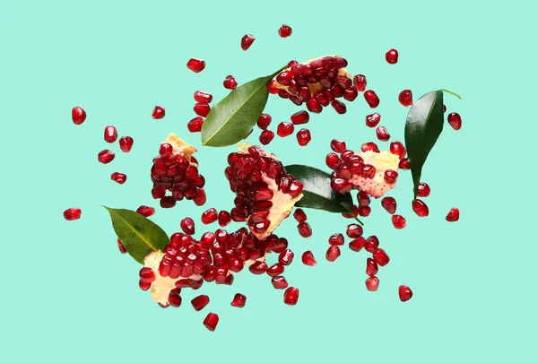 Flying Fresh Pomegranates Seeds Leaves Turquoise Background — Stock Photo, Image