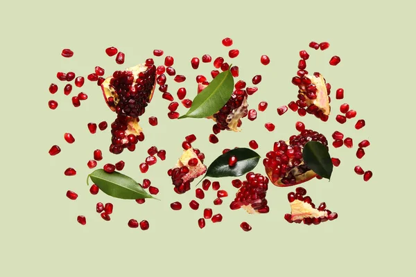 Flying Fresh Pomegranates Seeds Leaves Green Background — Stock Photo, Image