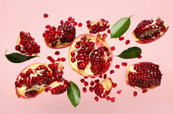 Fliegende Frische Granatäpfel Mit Samen Und Blättern Auf Rosa Hintergrund — Stockfoto